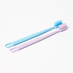 Two slim toothbrushes lying flat on white background, one blue and one light purple