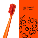 Close-up of orange Boie toothbrush head and handle next to orange panel with 'Extra-soft bristles' text and bubble graphics.