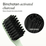 Close-up of toothbrush head with black Binchotan activated charcoal-infused bristles and inset magnified view showing dense bristles.