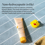 Boka Kids Orange Cream toothpaste tube placed on wet tiled surface next to a yellow rubber duck, with nano-hydroxyapatite description above.