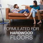 Lifestyle photo of family relaxing on a couch with a Bona mop visible on a dark hardwood floor and text about hardwood
