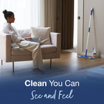 Staged room scene with a Bona mop and bottle by a wall while a person relaxes on a sofa in the background