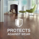 Decorative room with a dog near a fireplace and hardwood floor graphic with shield icon and text 'Protects Against Wear'