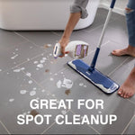 Lifestyle image of a person using a Bona spray bottle and mop to spot-clean a tiled floor with suds and dirt marks.