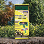 Bonide MoleMax packaging displayed outdoors showing yellow front panel and green solar sonic spike against garden background