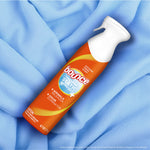 Bounce Instant Static Remover bottle photographed lying on a soft blue fabric backdrop to suggest use on garments