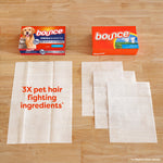 Top-down image of two Bounce boxes and unfolded sheets on wood surface with text '3X pet hair fighting ingredients'