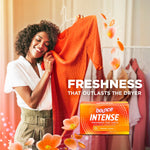 Woman smelling a bright orange garment in a laundry setting with a Bounce Intense box and 'Freshness that outlasts the dryer' text.