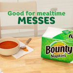 Bounty Napkins pack on a wooden table next to a bowl and spoon with text ‘Good for mealtime MESSES’