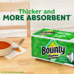 Kitchen scene with Bounty napkins package on a wooden table and a bowl with a napkin-stained spoon