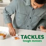 Person wiping a red sauce spill on a white countertop with a Bounty paper towel, text reading tackles tough messes