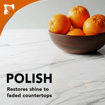 Wood bowl of oranges on a polished marble countertop with text reading “POLISH” and note about restoring shine to countertops