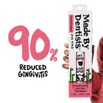 Hand holding boxed Made By Dentists toothbrush beside large pink ‘90% reduced gingivitis’ graphic