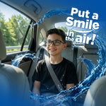 Smiling boy seated in the back of a car with water splash graphics and text ‘Put a Smile in the air!’ promoting Little Pup scent