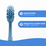 Close-up toothbrush head with tapered ultra-soft bristles and callouts reading ‘tapered bristles’ and ‘designed for sensitive teeth’