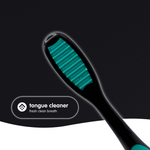 Close-up of a Brush Buddies toothbrush showing a teal tongue cleaner on the back of the brush head with feature label.