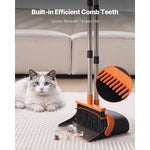 Broom and dustpan set on a rug with visible built-in comb teeth inset and a cat sitting in the background next to a sofa.