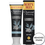 Single Burt's Bees Charcoal + Whitening toothpaste tube standing next to its black carton packaging with botanical illustration
