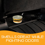 California Scents Hollywood Glow can sitting on a car floor mat near an umbrella with orange graphic text about fighting odors beneath.