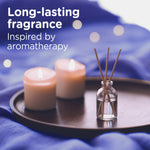 Tray with lit candles and reed diffuser on a purple fabric background illustrating long-lasting fragrance