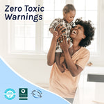 Smiling adult lifting a small child in a bright kitchen with 'Zero Toxic Warnings' text and certification badges below
