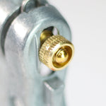 Tight close-up of a brass adjustment knob and threaded valve on a metal Chapin hose nozzle