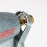 Close-up macro of Chapin hose nozzle latch and brass adjustment screw with part of the metal body visible