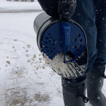 Close action shot of Chapin spreader dispensing ice melt granules onto snow