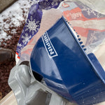 Close angled photo of a blue Chapin spreader resting near a decorative holiday bag, showing the CHAPIN logo.