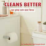 Bathroom scene showing a toilet and mounted Charmin roll with 'Cleans better so you can use less' headline