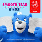 Blue Charmin bear smiling and holding torn toilet paper sheets with ‘Smooth Tear is here!’ text