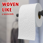 Close-up of a Charmin embossed toilet paper roll on a holder with text 'WOVEN LIKE a washcloth' in the corner