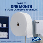 Large Charmin Forever Roll mounted on a stainless steel stand in a tiled bathroom with text about lasting up to one month.