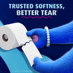 Close-up of blue-furred hands tearing Charmin Ultra Soft embossed toilet paper with headline about trusted softness