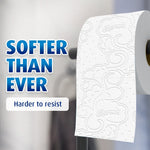 Close-up of a patterned Charmin toilet paper roll on a holder with text 'SOFTER THAN EVER' beside it
