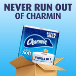Promotional graphic of a Charmin Ultra Soft Super Mega pack emerging from a box with headline 'Never run out of Charmin'.