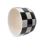 Angled view of a round ceramic planter with a glossy black-and-white checkerboard design, shown on its side.