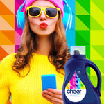 Woman in bright clothing and headphones with a cheer colorguard detergent bottle against a geometric multicolor background