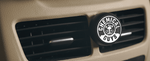 Chemical Guys Black Frost vent-clip air freshener attached to a vehicle air vent in a lifestyle interior shot