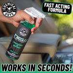 Hand holding a Chemical Guys New Car Smell spray bottle over a car seat with a 'Fast Acting Formula' callout