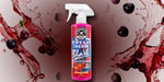 Chemical Guys Fresh Cherry Blast spray bottle set against a red splash background with floating cherries for a dramatic product lifestyle image