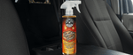 Chemical Guys Signature Scent spray bottle placed on a vehicle center console with car seats visible