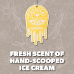 Yellow drip-shaped Chemical Guys vanilla bean hanging air freshener suspended on a neutral floral background with scent copy
