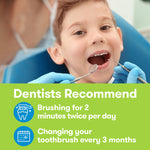 Smiling child in a dental chair being examined, with overlay text recommending two-minute brushing and toothbrush replacement