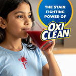 Child drinking red juice with visible shirt stain and OxiClean badge graphic promoting stain-fighting power