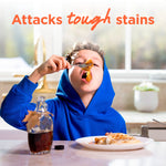 Child in a blue hoodie eating syrupy pancakes at a table, with overlay text 'Attacks tough stains'