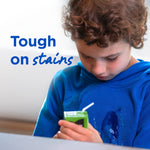 Close-up of a child in a blue hoodie with visible stains and text reading 'Tough on stains' to the left