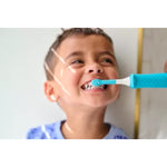 Child smiling as a turquoise-and-white Philips Sonicare kids toothbrush head brushes their teeth in a lifestyle photo