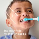 Child smiling while a turquoise-and-white Philips Sonicare toothbrush head brushes their teeth, promotional text for ages 3+