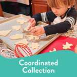 Child placing clear plastic cup of sprinkles onto a baking sheet while making cookies in a kitchen